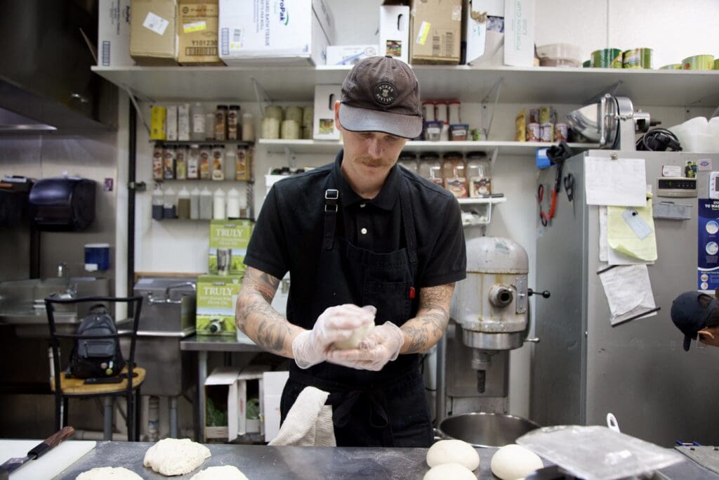 a person standing in a kitchen preparing food