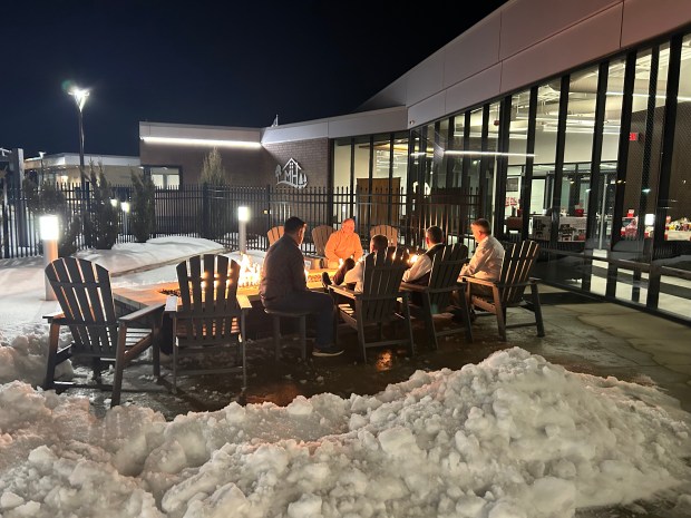 People gather around a gas fireplace outside the Mayfield Heights Aquatic and Community Center during a taste of Italy event on Feb. 14. (Frank Mecham- The News-Herald)