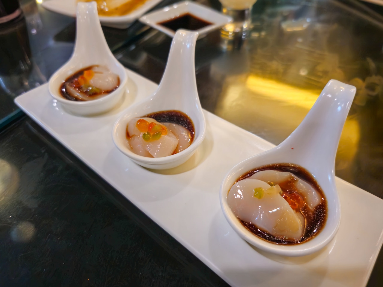 Spoons of scallop served with kizami wasabi and Ikura house sauce at Hidden Fish in Skaneateles.
