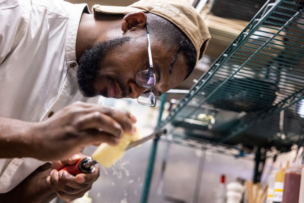 Chef Tyiquan McDuffie grates parmesan cheese over his duck confit ravioli dish at Still Worldly Eclectic Tapas in Portsmouth on Wednesday, Jan. 14, 2026. (Kendall Warner/The Virginian-Pilot)