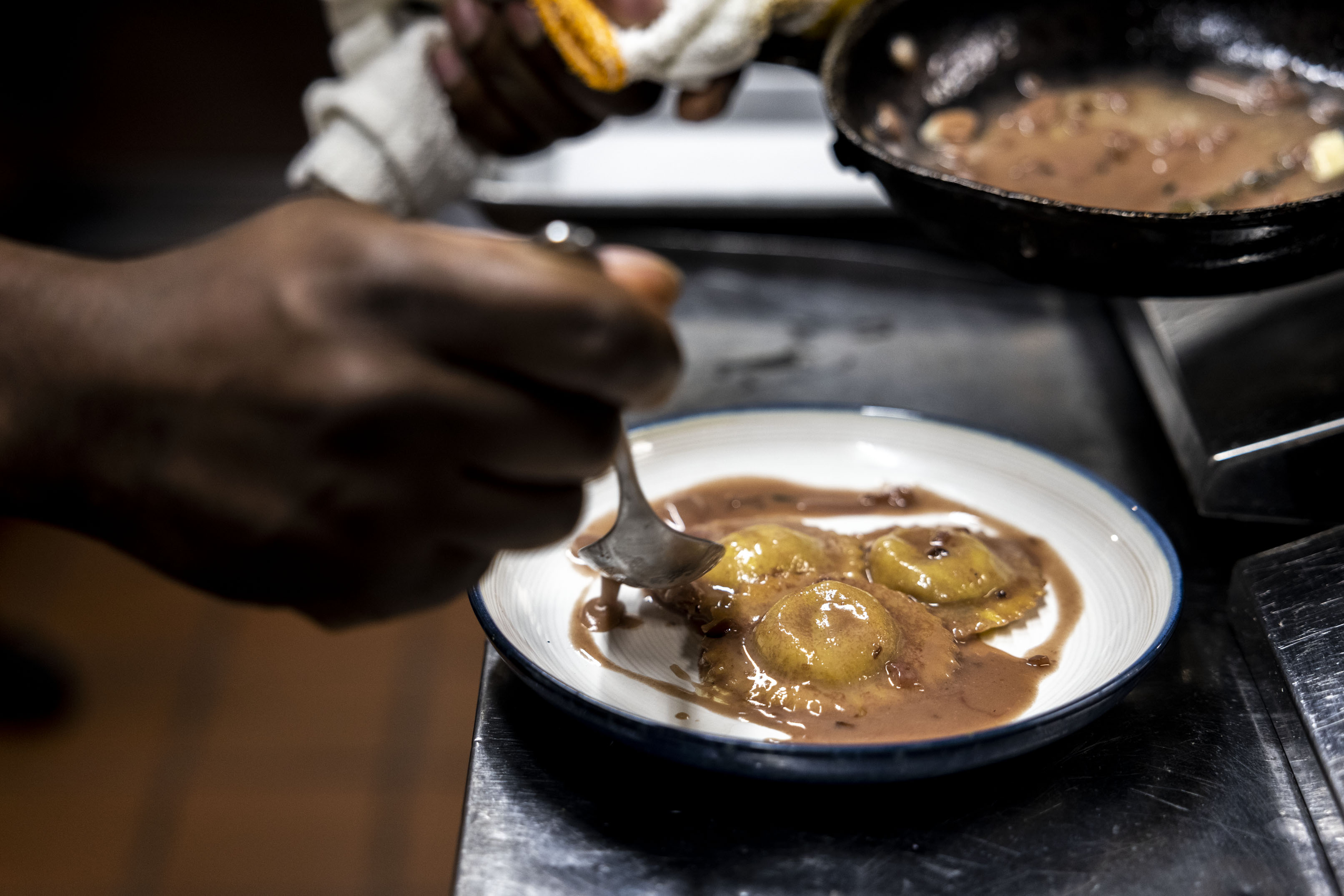 Chef Ty McDuffie drizzles beurre rouge sauce over his duck...
