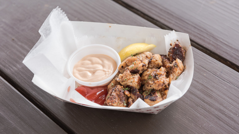Alligator tail in a bowl with dipping sauce