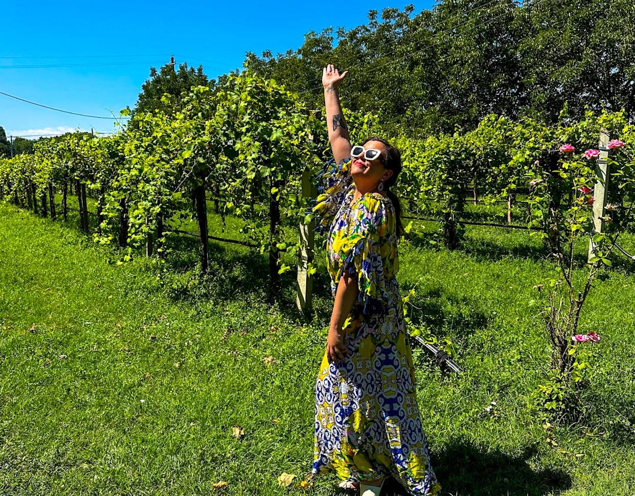 The writer in a dress, standing in a vineyard in Modena.