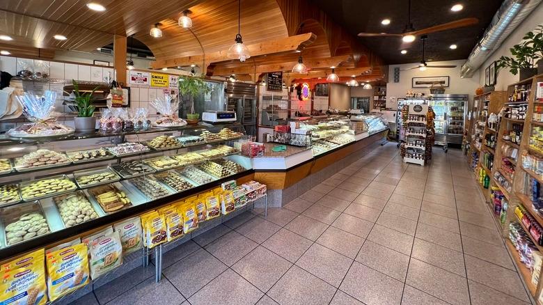 Deli counter showing cold cuts, cheeses, and olives in a glass-front case