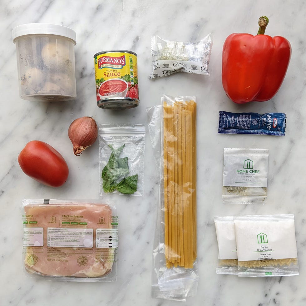 Ingredients for a pasta dish laid out on a marble surface.