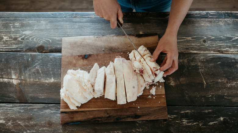 Hands cutting beef tallow on a cutting board