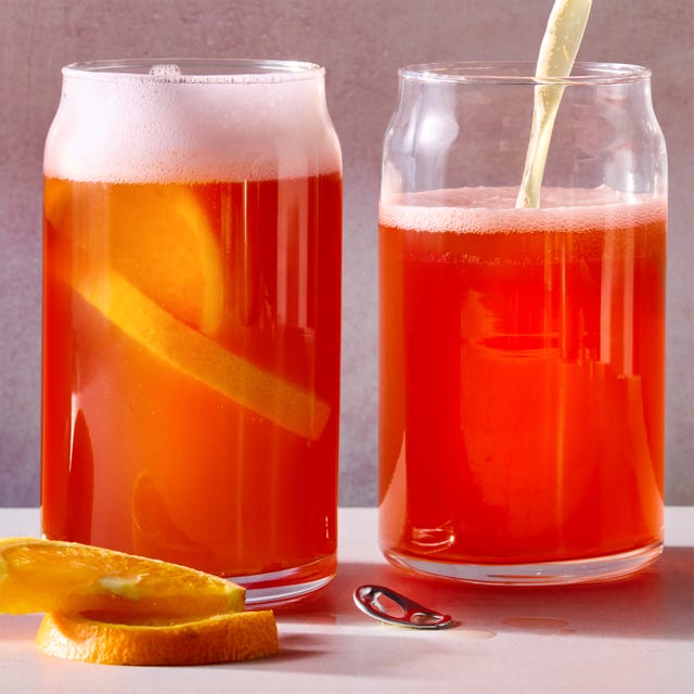 campari and beer in a tall glass with an orange wedge