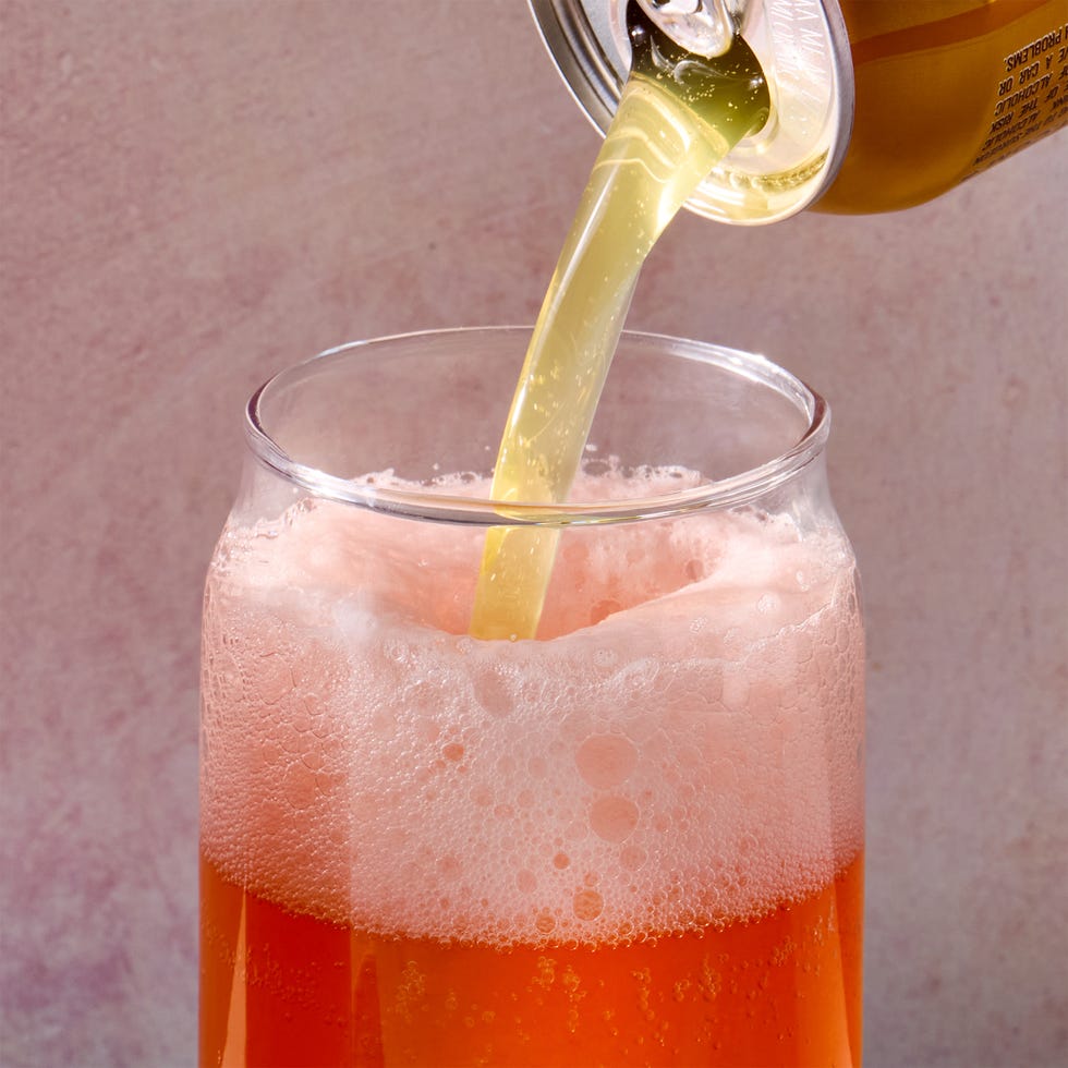 campari and beer in a tall glass with an orange wedge