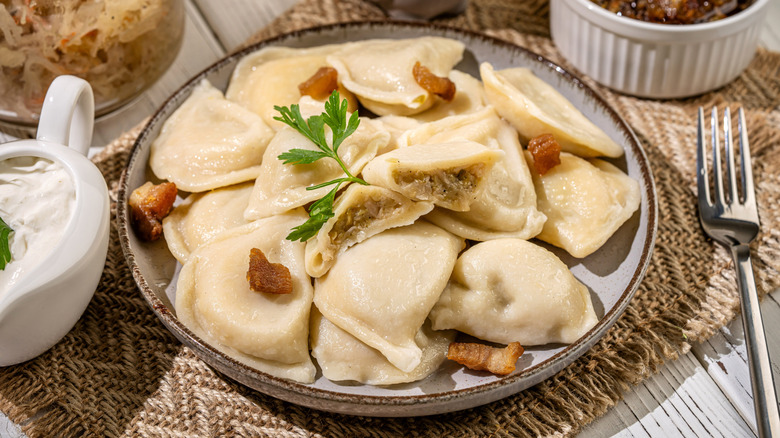 Pile of cabbage dumplings on plate with crispy bacon pieces
