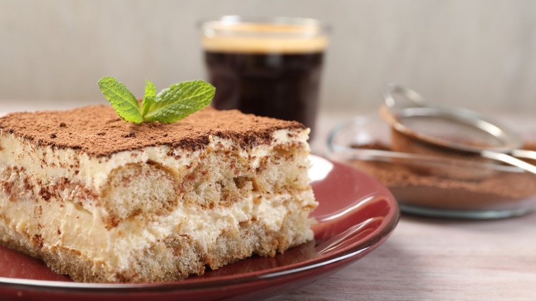 closeup tiramisu with coffee in the background