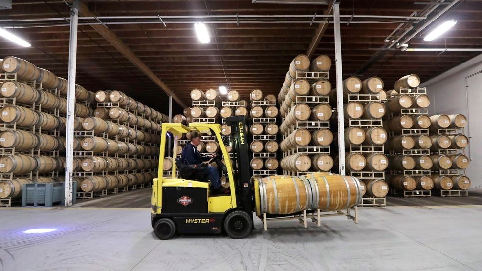 FILE- In this photo taken Thursday, Nov. 21, 2019, barrels of wine are moved into storage at Chateau Ste. Michelle Winery in Woodinville, Wash. (AP Photo/Elaine Thompson)