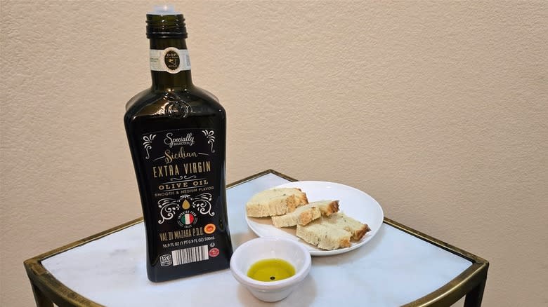 a bottle of specially selected EVOO from Aldi on a table with bread