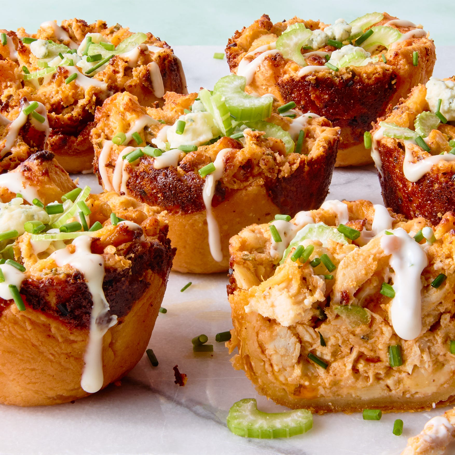 classic buffalo chicken dip with chopped chicken, cream cheese, cheddar, blue cheese, hot sauce, and chives baked into a crisp puff pastry shell until bubbling and golden