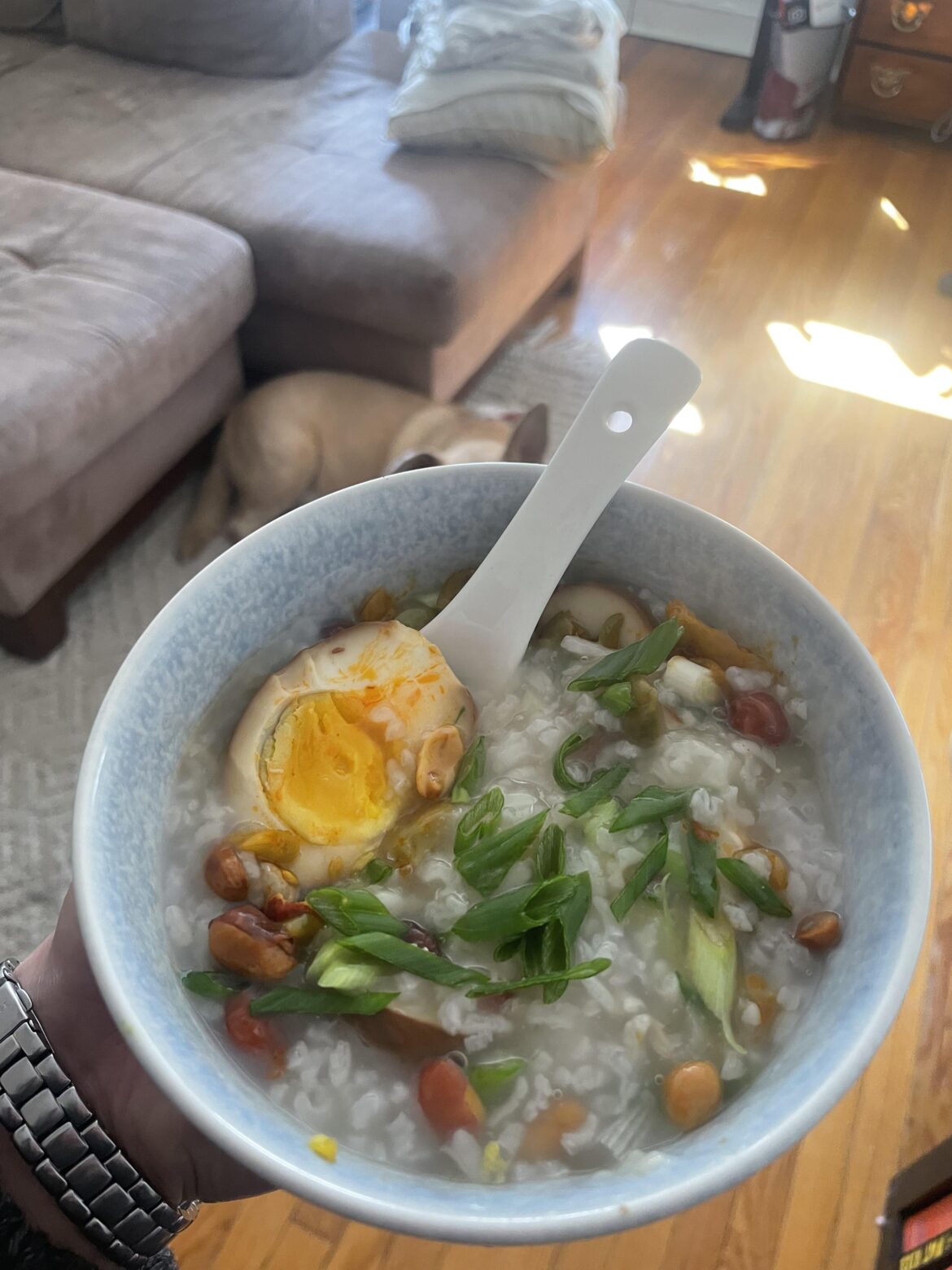 Congee topped with homemade tea eggs, fried peanuts, pickled mustard greens and scallions