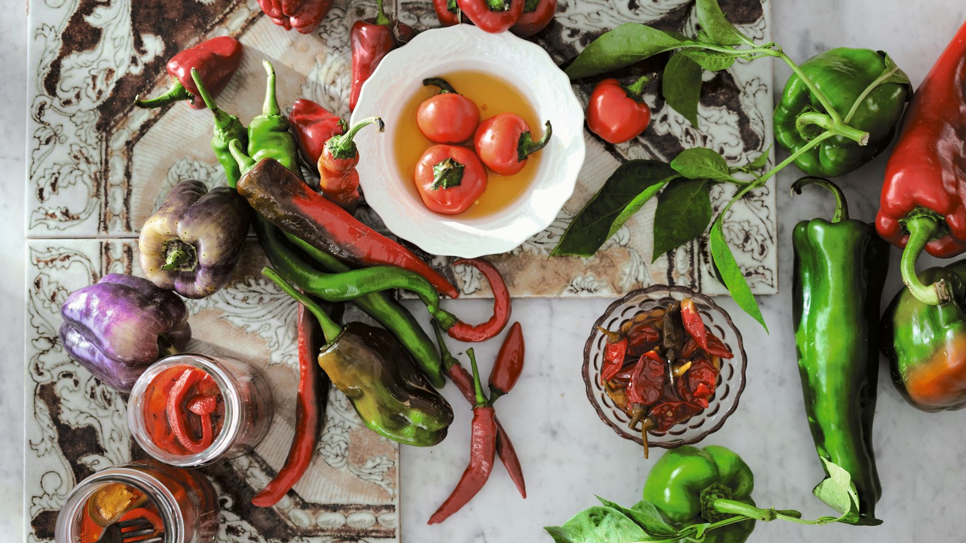 Tomatoes and peppers on a tiled table