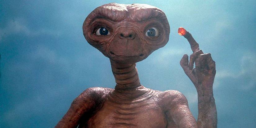E.T. with a glowing finger looking straight ahead in E.T. the Extra-Terrestrial