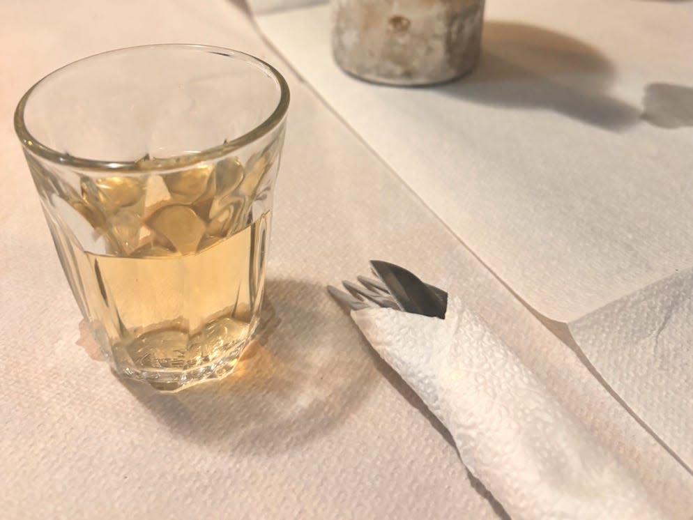 A small glass of white wine on a dinner table.