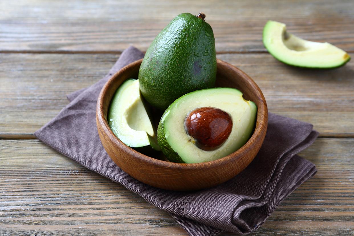 Avocados in a wooden bowl.
