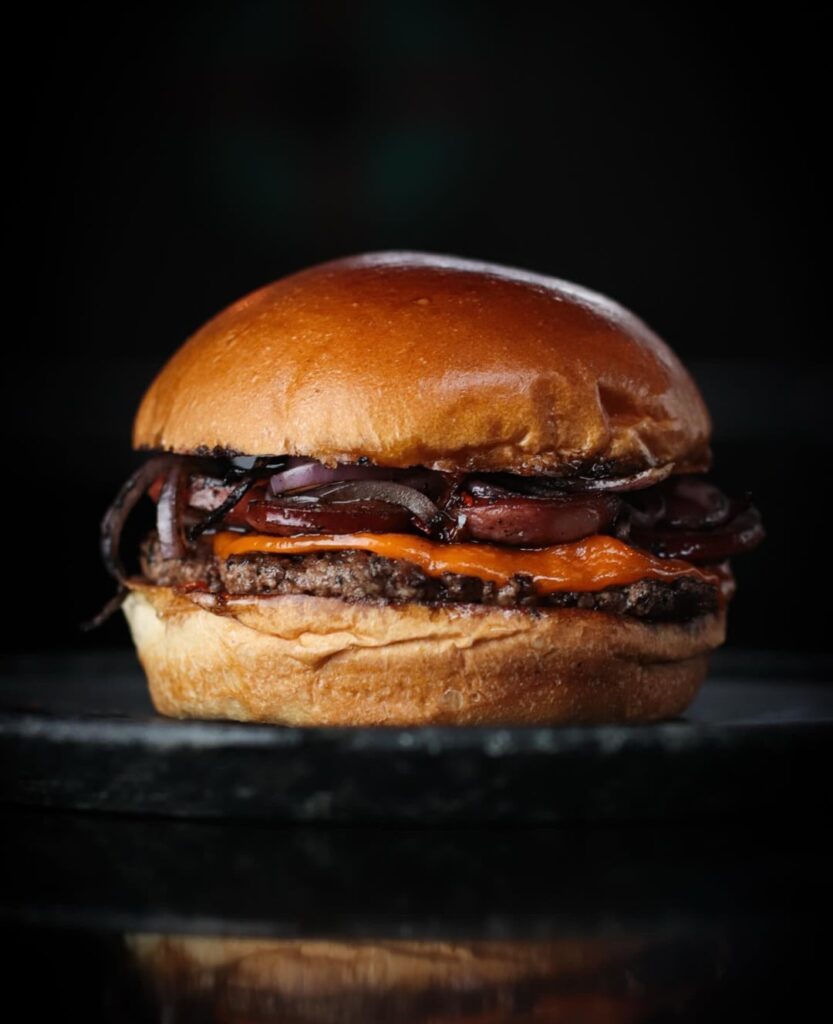 Smash Burger with calabrese sausage, onions and Hot Honey.