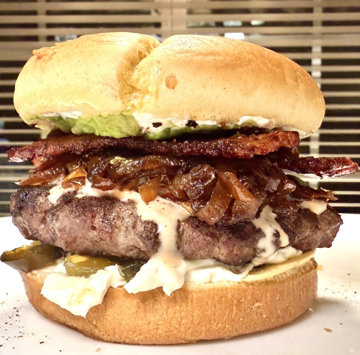 Hamburger with cream cheese, avocado, bacon, tomato, caramelized onions, and candied jalapeños.