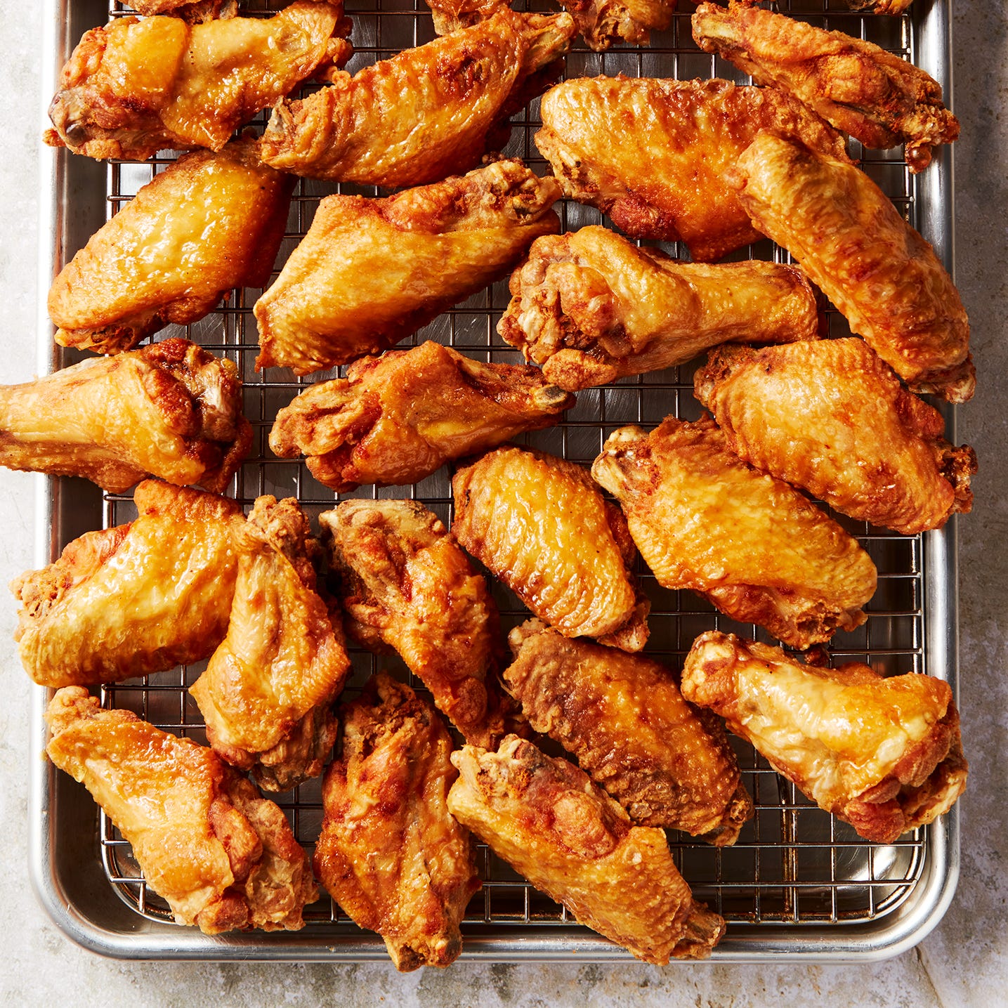 crispy golden brown fried chicken wings on a pan