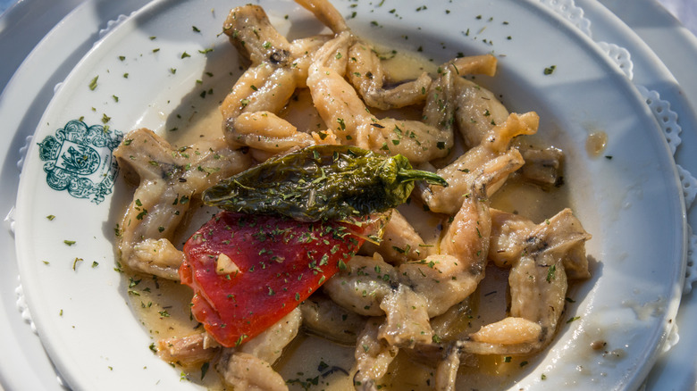 Plate with frog legs, peppers, and seasoning