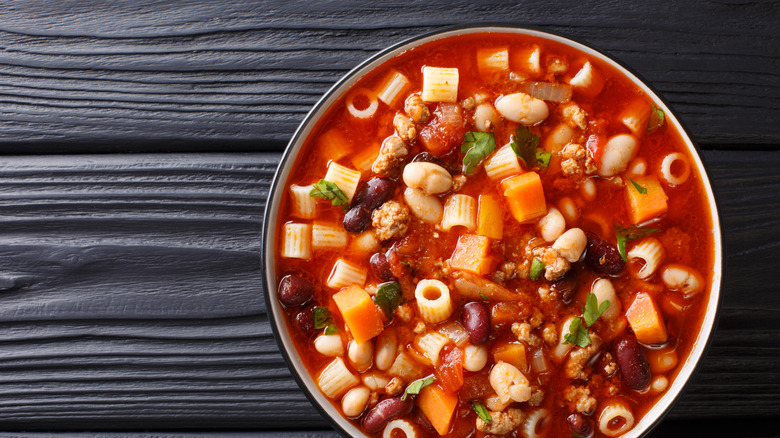 A big bowl of fagioli filled with meat, veggies, beans, and pasta.