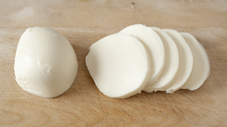 Fresh mozzarella sliced on a cutting board