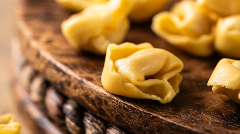 Fresh tortellini on wood board close up
