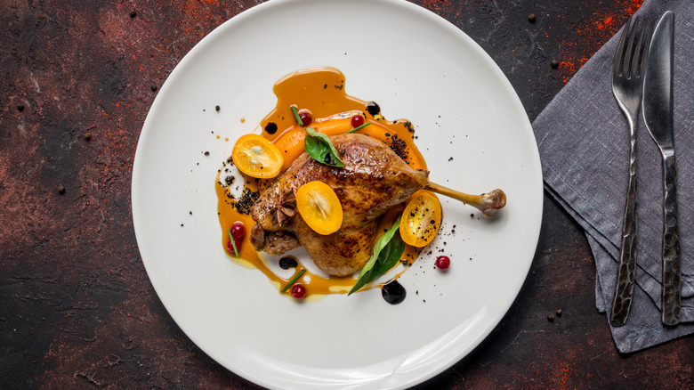 Duck leg confit on a white plate