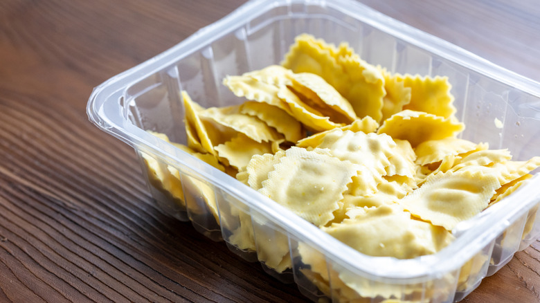 an opened plastic container with ravioli inside
