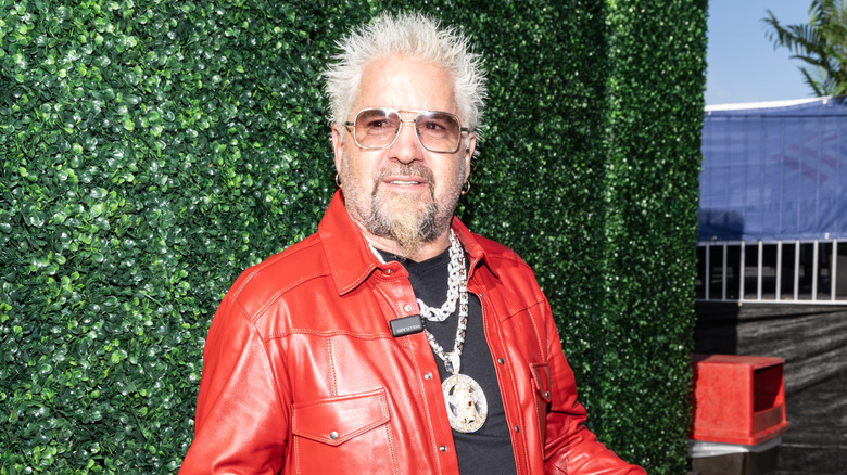 Guy Fieri in red leather jacket with diamond necklace