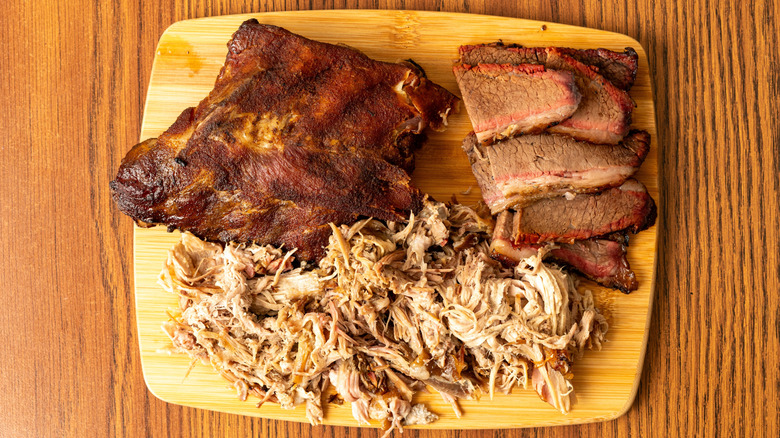 A BBQ meat sampler board, with brisket, pulled pork, and ribs
