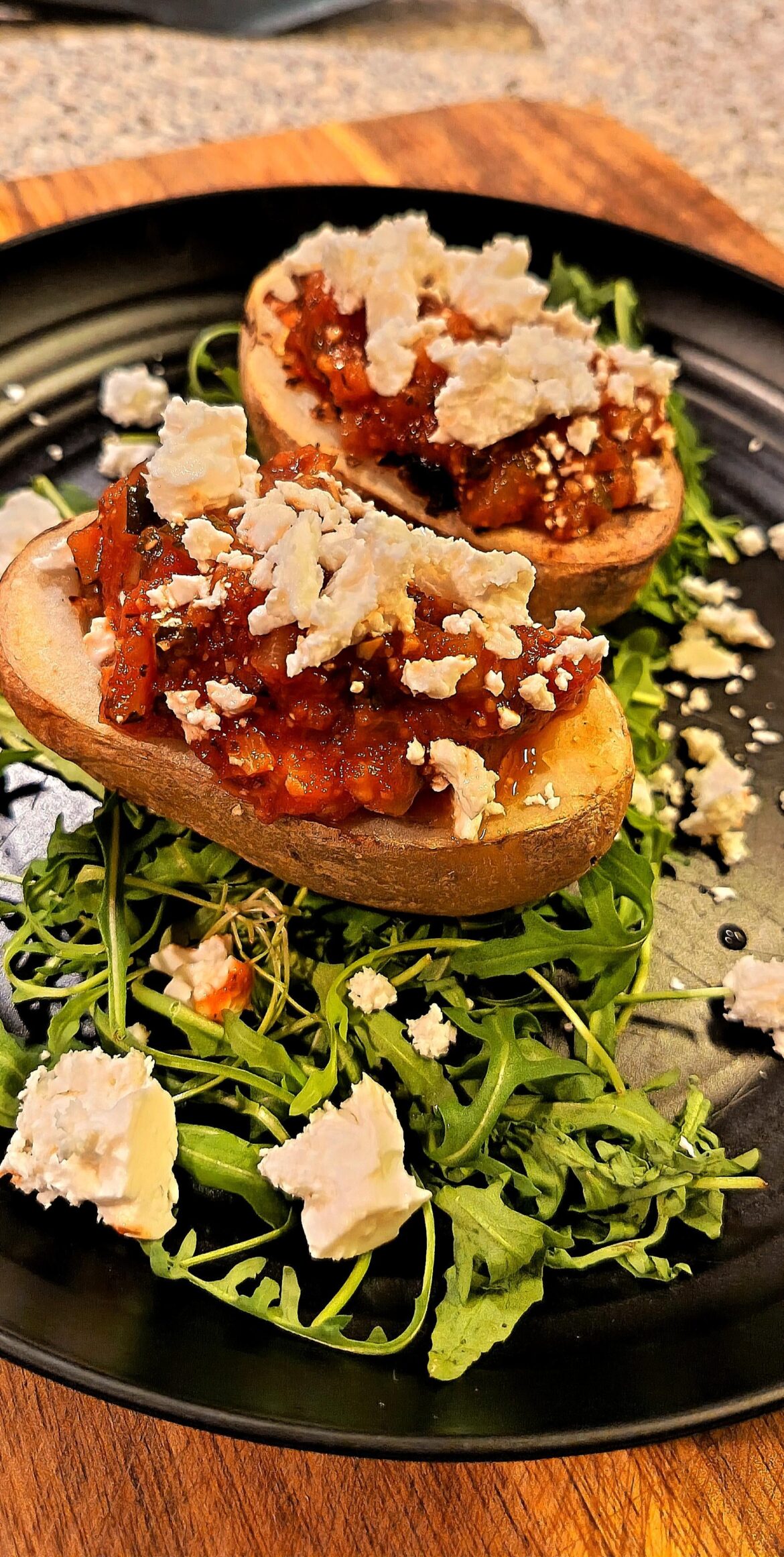 Roast potatoes skins stuffed with ratatouille and topped with feta cheese