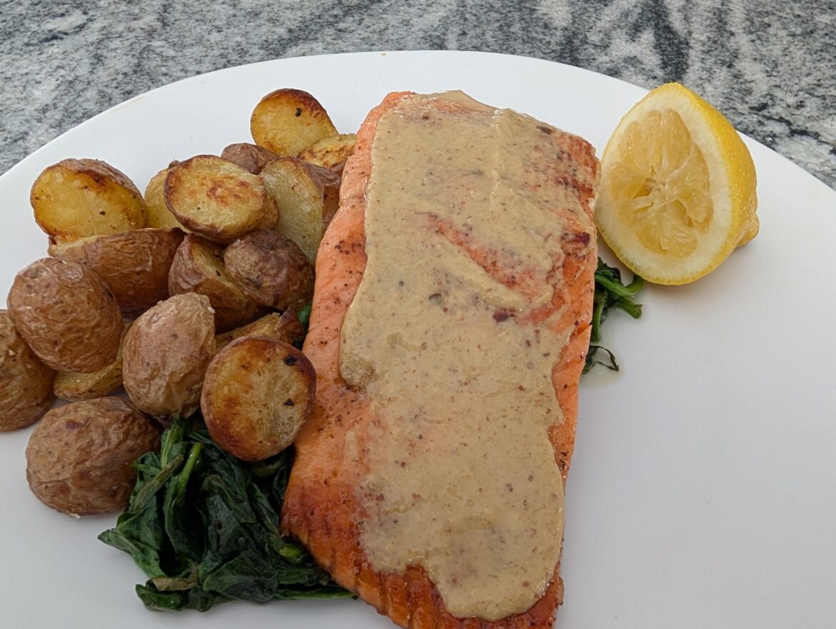 Seared Salmon Dijonaise with crispy potatoes and sauteed Garlic Spinach.