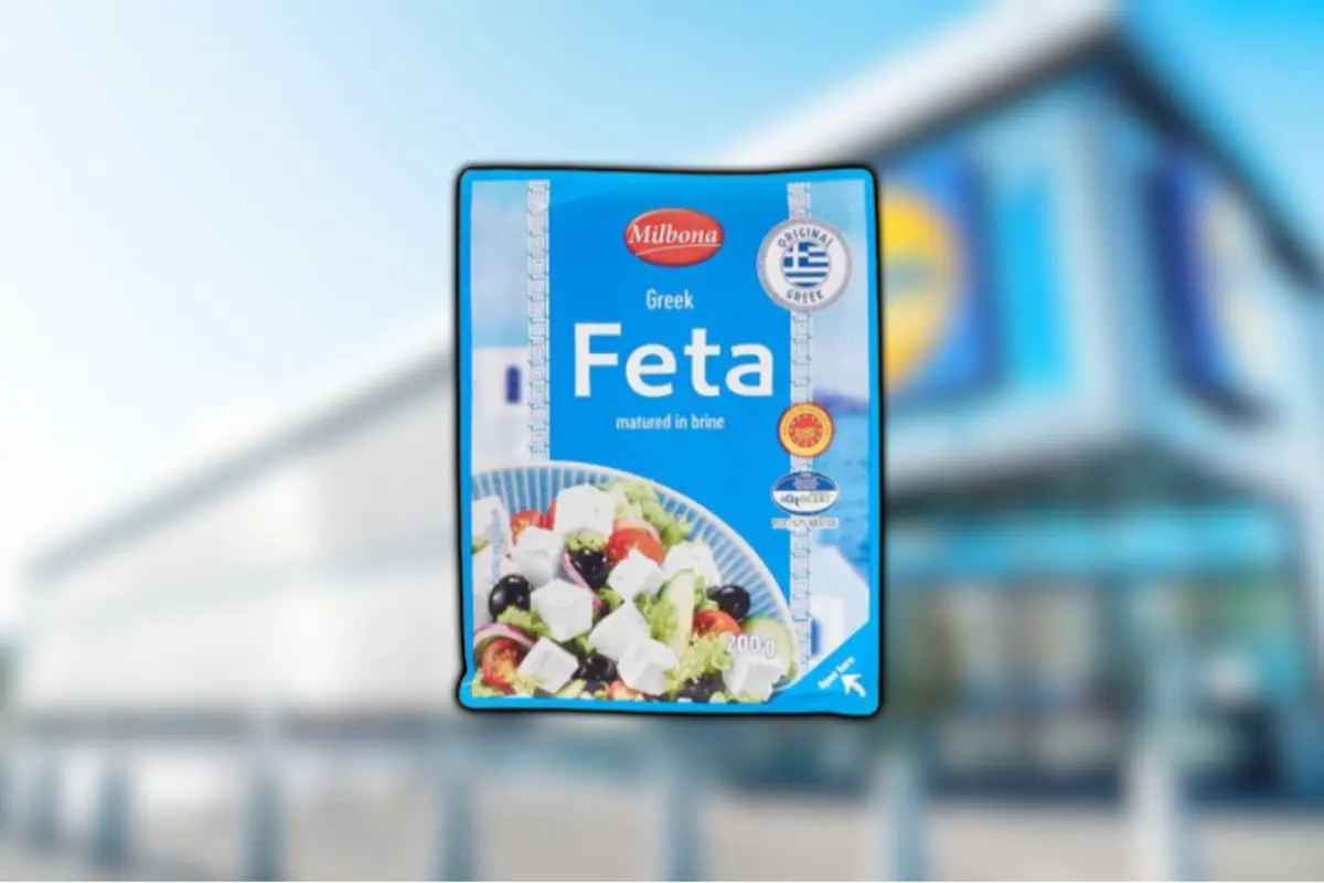 Greek Milbona brand feta cheese container against a blurred supermarket background