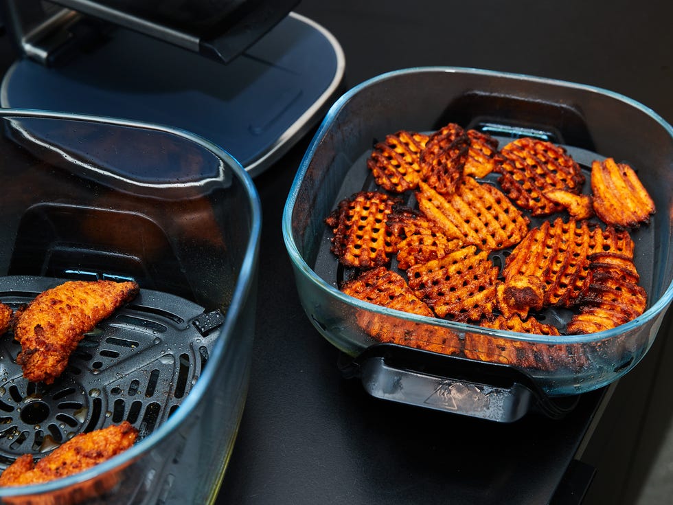 cooked chicken pieces and waffle fries in glass cooking trays