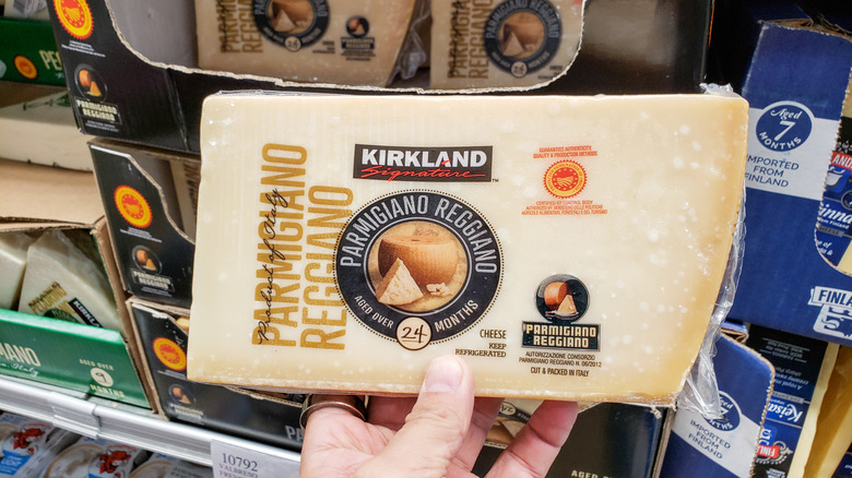 Hand holding kirdland parmigiano reggiano cheese