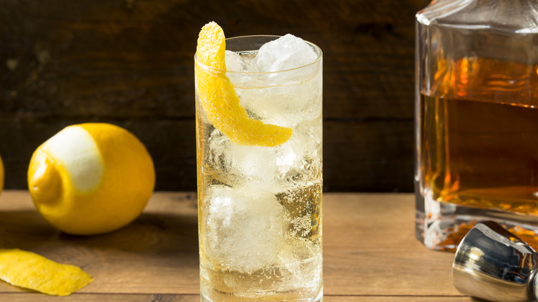A Scotch and soda with a lemon twist in a highball glass.
