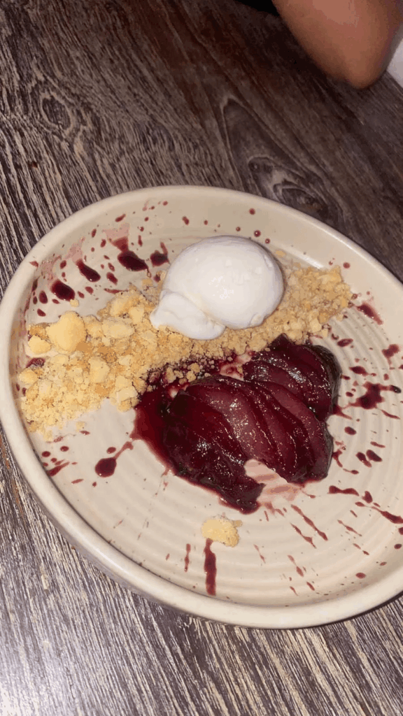 Poached pear with vanilla ice cream and crumble