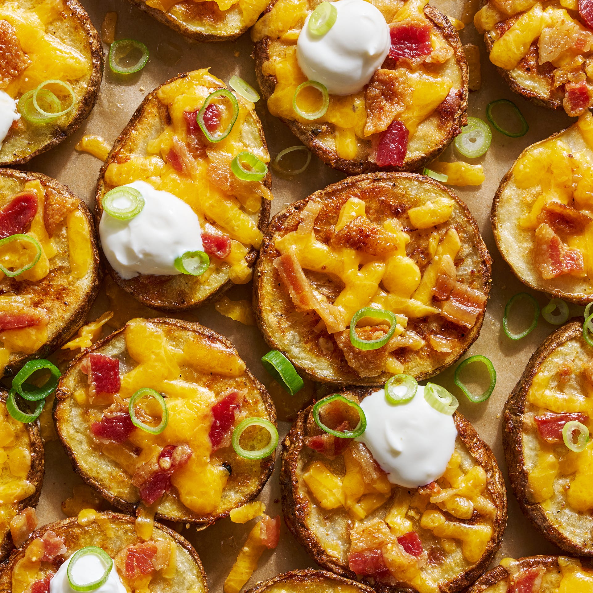 circles of crispy potatoes with melted cheese, bacon and dollops of sour cream
