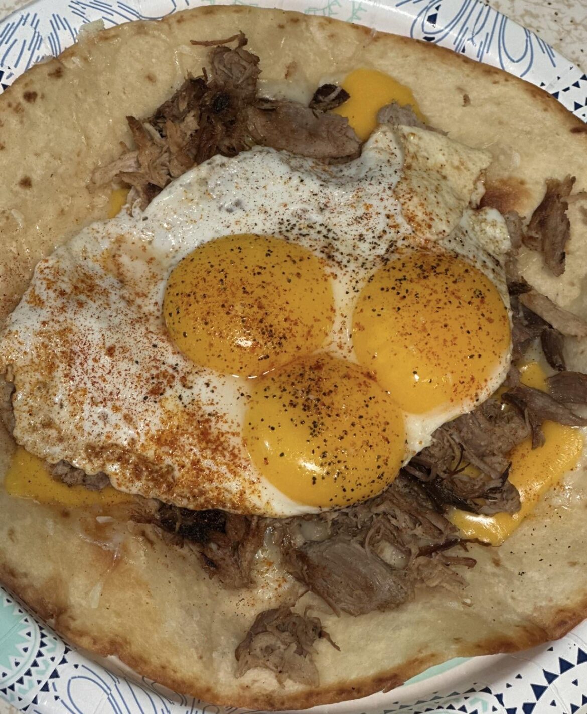 Crispy Tortilla with Vinegar Pulled Pork, Melted Raclette, and a Triple Yolk Sunny