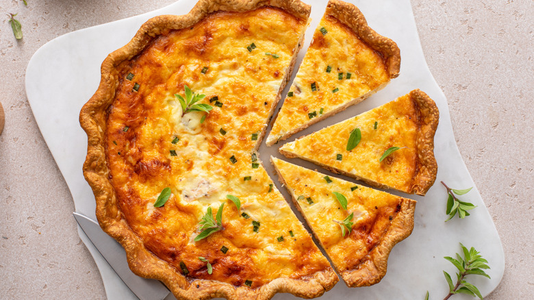 Top down view of sliced quiche on serving plate