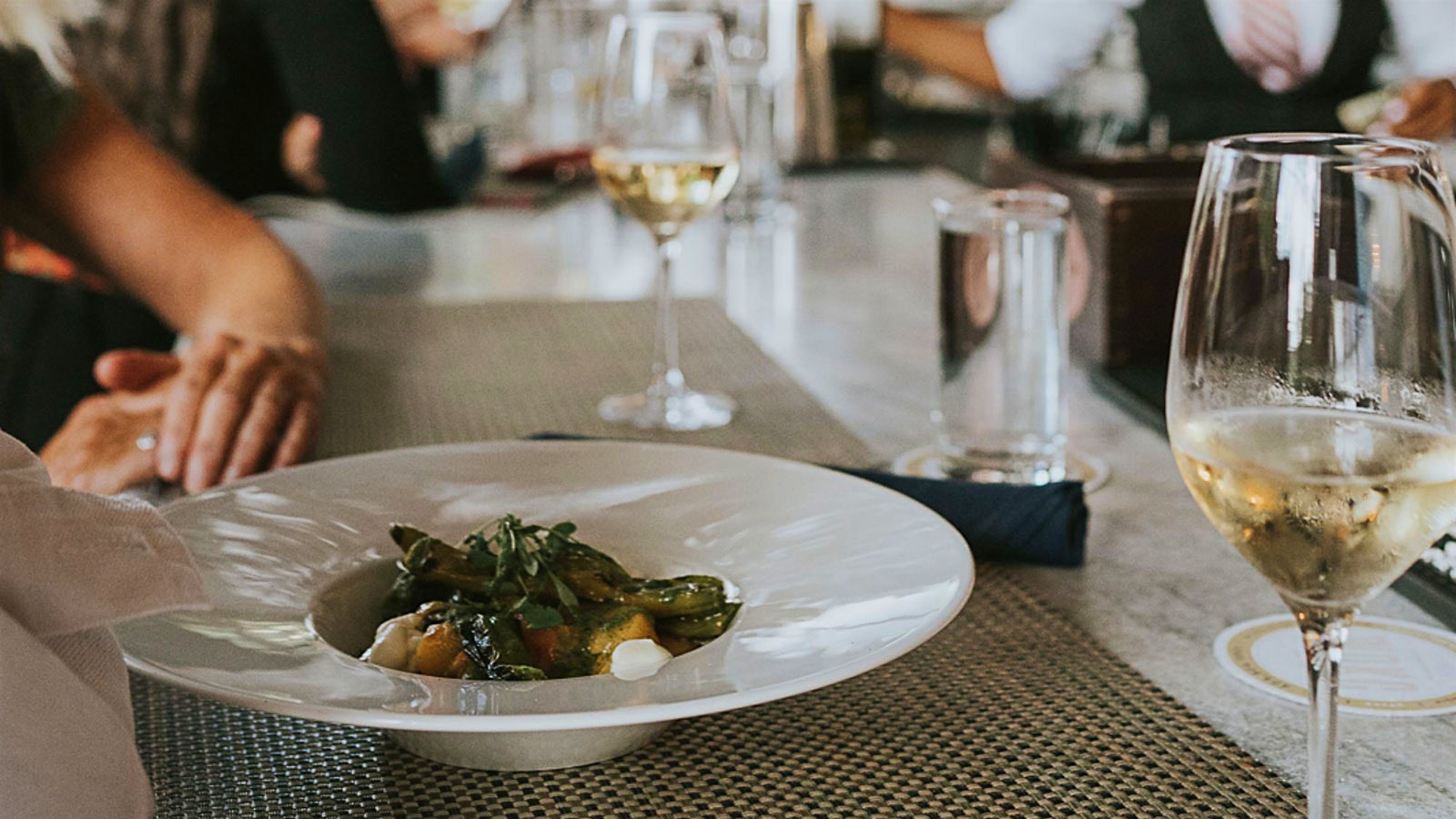  A vegetable dish and glasses of white wine from White Oak Kitchen & Cocktails 