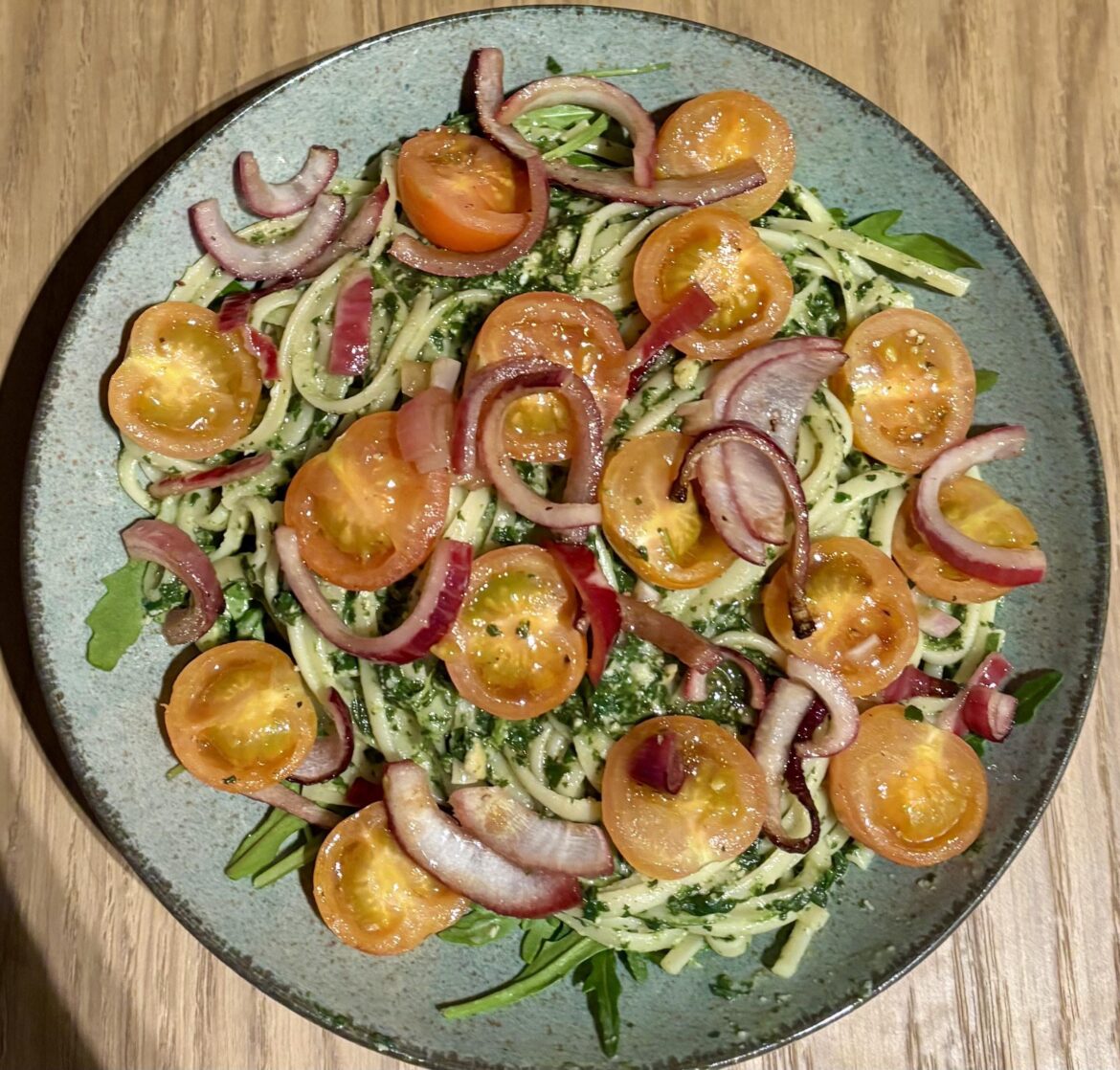 Spaghetti with a homemade pesto, rucola, roasted cherry tomatoes and red onions.