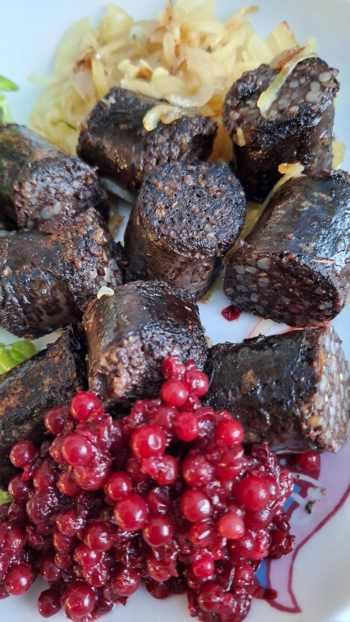 Blood sausage (mustamakkara) with fried onion and lingonberries.