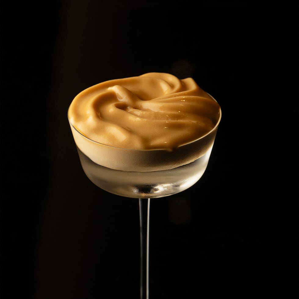 a glass cup filled with a whipped creamy substance on a sleek surface