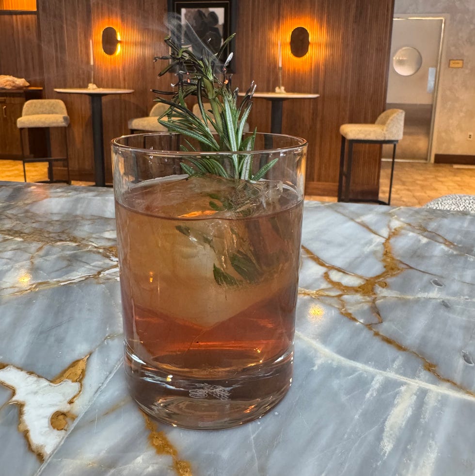 cocktail served in a glass with a garnish on a marble table