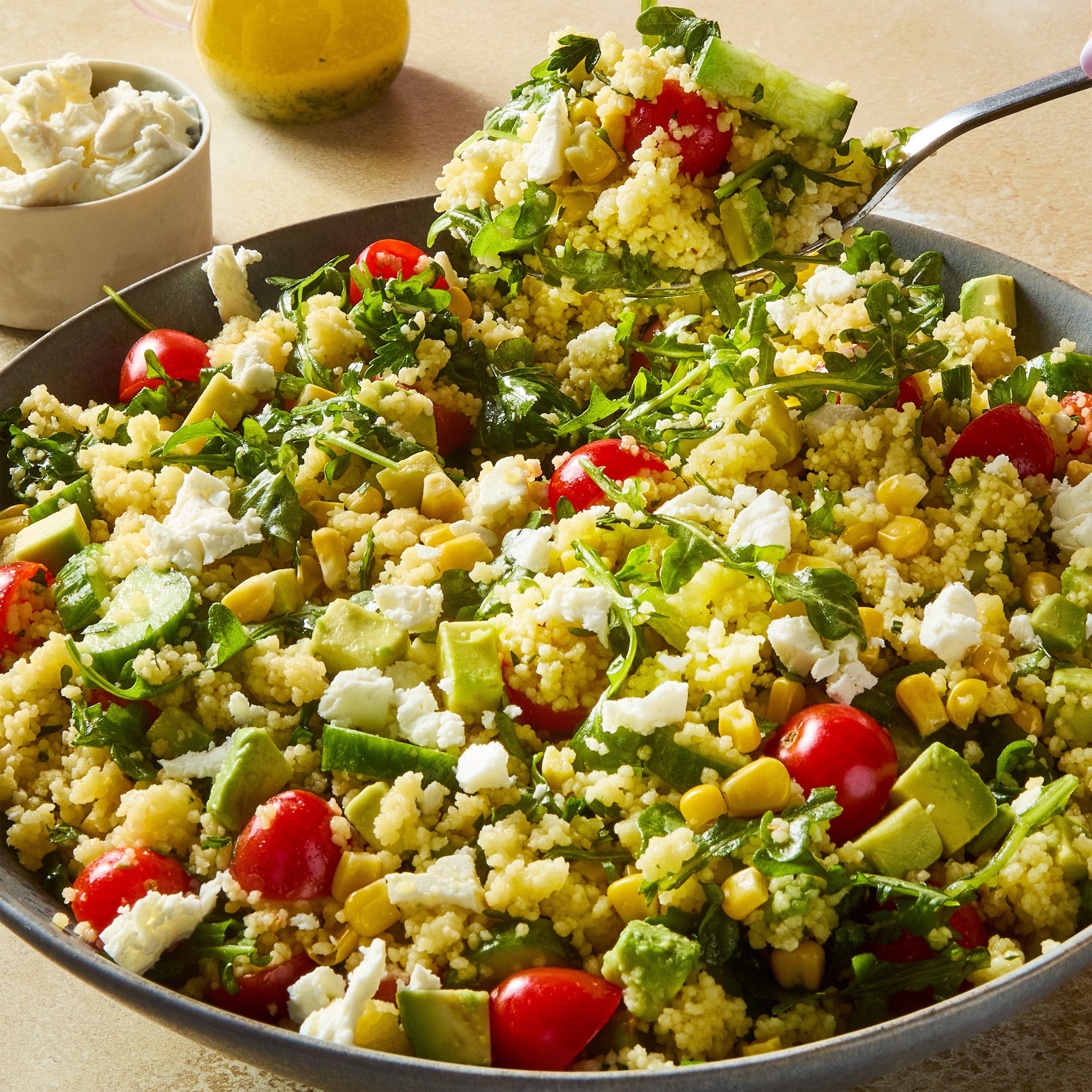 summer couscous salad with cucumber, tomato, avocado, and feta