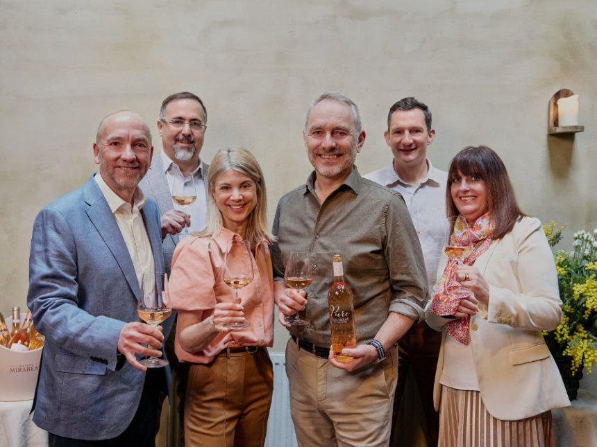 Members of Viña Concha y Toro and Maison Mirabeau stand smiling with glasses of wine